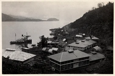 View of a group of buildings near a large body of water during the construction of the Panama Canal